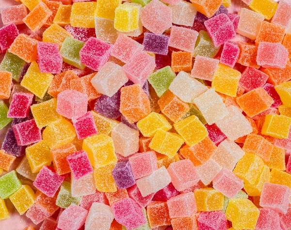 Colorful candy and jelly on pink background