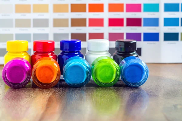 Bottles color on wood with background color chart