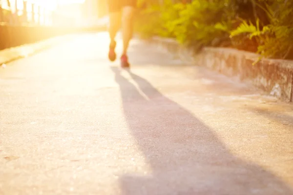 Woman athlete running on street for health, blurred sport background