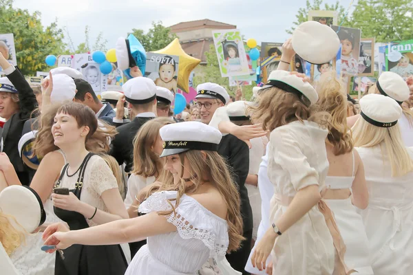 Happy teenagers wearing graduation caps celebrating the graduati