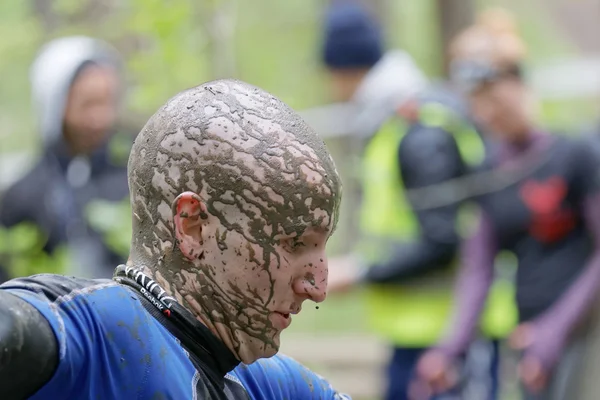 Balled man, head covered with mud