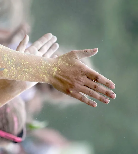Clapping hands covered with yellow color powder