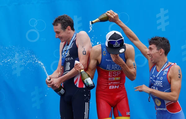The medalist triathletes squirting champagne on the podium