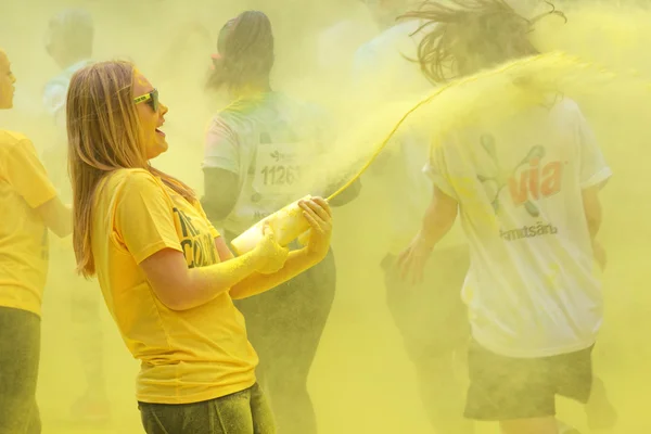 One of the official woman squirting yellow color powder on the r