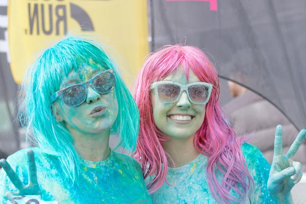 Two happy girls wearing sun glasses covered with color powder