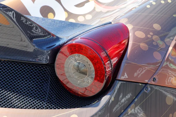 Taillight on a fast sports-car before the start of the public ev