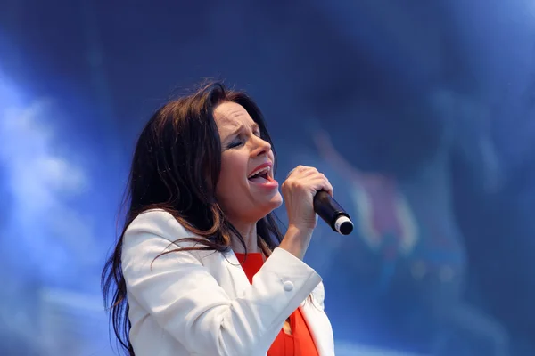 Woman in white jacket singing