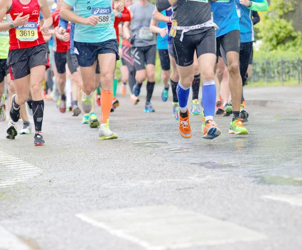 Feet, legs and torsos of a large group of runner