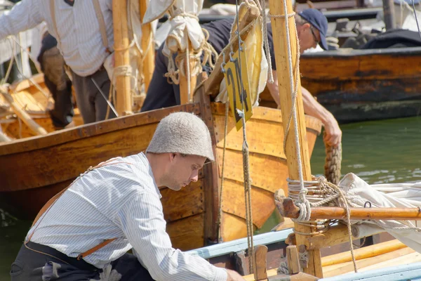 Sailors in vintage clothes preparing old sailing ships