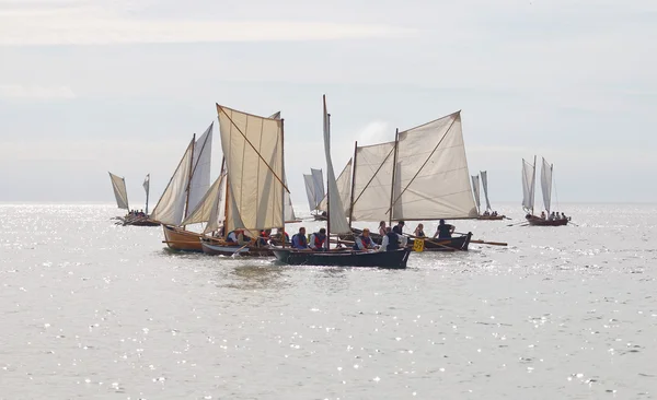 Large group of small, old sailing ships in chaotic situation