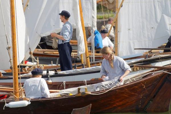 Sailors in vintage clothes preparing old sailing ships