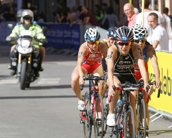 Triathlete Yuko Takahashi cycling, followed by competitors
