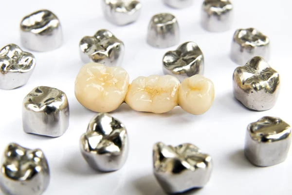 Dental ceramic, gold and metal tooth crowns on white background. Isolated.