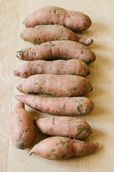 Sweet potatoes on wooden background