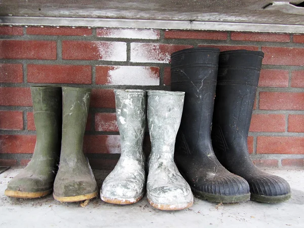 Rubber boots on the brick wall background