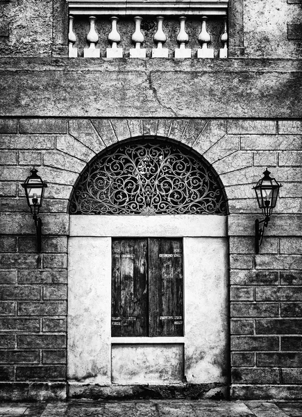 Facade of an ancient Italian villa with artistic iron grill.