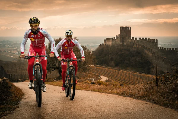 Cyclists train on the hills surrounding the castle of Soave.