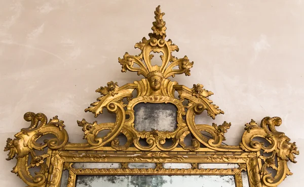 Detail of gilded frame of an antique mirror.