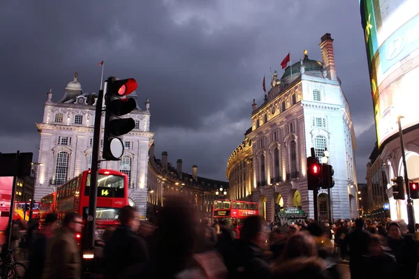 Piccadilly Circus, London -  February 14th of 2015: Lots of people, cars and typical red buses crossing the streets in this famous public space in London\'s West End that was built in 1819.