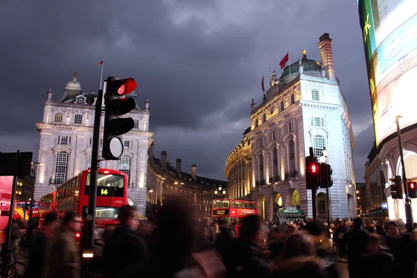 Piccadilly Circus, London -  February 14th of 2015: Lots of people, cars and typical red buses crossing the streets in this famous public space in London's West End that was built in 1819.