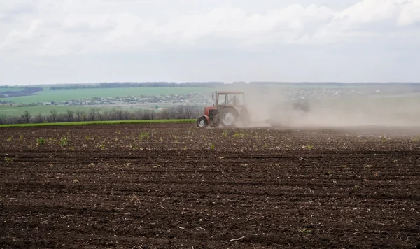 Ukraine, a ploughed field and a tractor in the dust