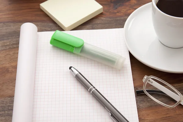 Office table with cup of coffee and empty paper