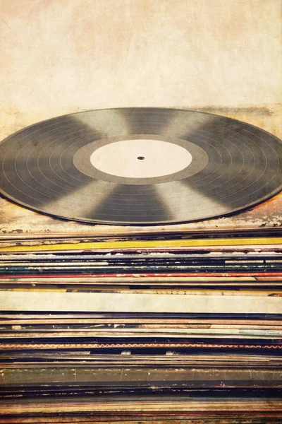 Vinyl record on a tower of album covers, textured, vintage, retro