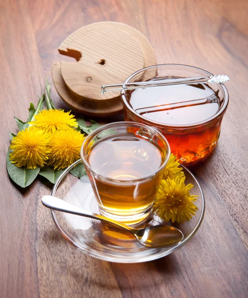 Herbal tea and honey made of fresh dandelion, blossom and leaf on wooden table