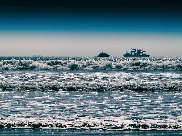 Horizontal vivid two ships in ocean tidal waves horizon backgrou