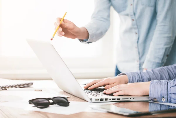 Website developers working using  laptop at the office on wooden