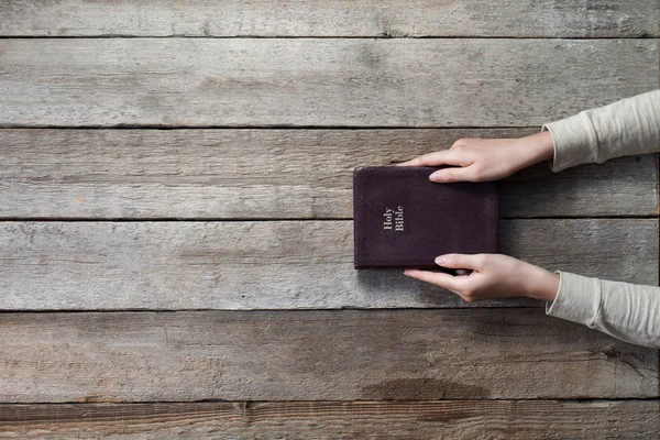 Woman hands on bible