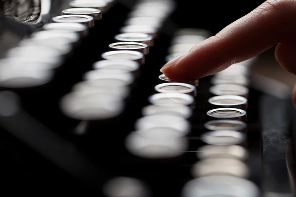 Hands writing on old typewriter over wooden table background