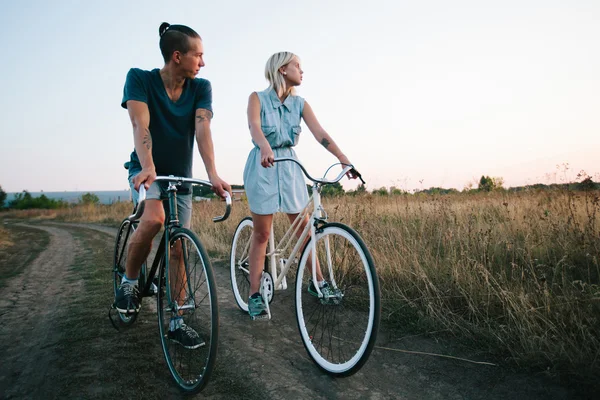 Young couple on vintage bikes riding