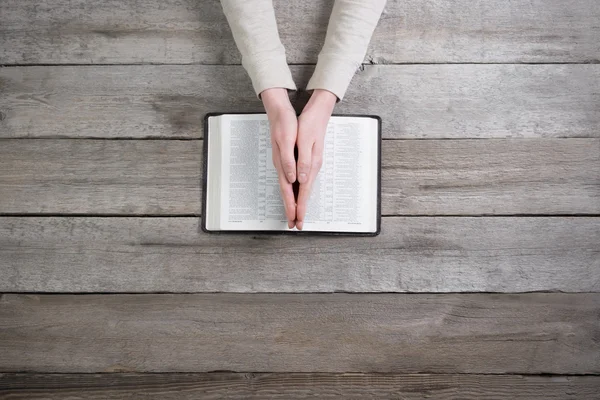 Woman hands on bible. she is reading and praying over bible over