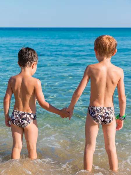 6-7 years boys in front of sea hand in hand
