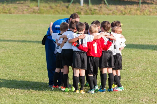 Little league players together in huddle, teamwork strategy to w