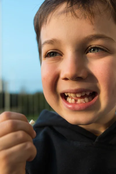 Young boy showing his first missing tooth