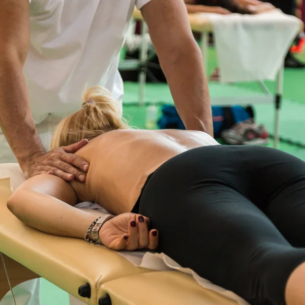 Blond Girl lying on Therapist\'s Table after Fitness Activity