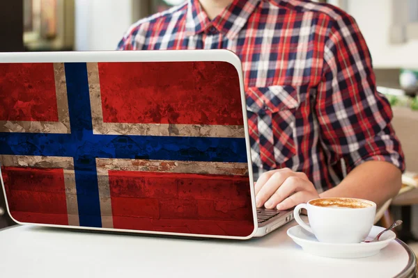 Man  in  cafe with notebook with Norway flag