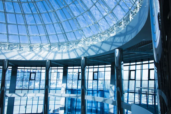 The original design of glass and metal in the form of a dome of a skyscraper, blue sky