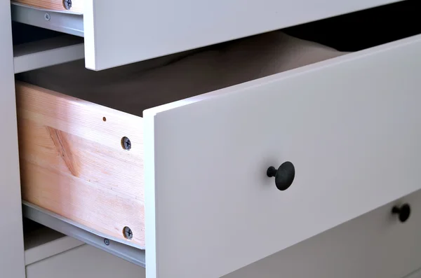 Detail of white laminated drawer with brass handle
