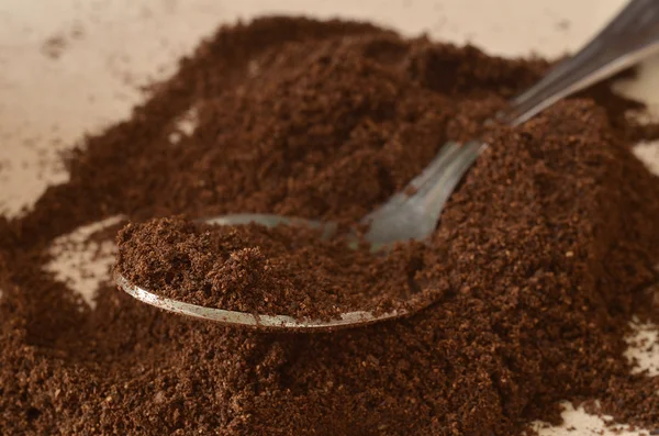 Spoon in light dark powder of coffee