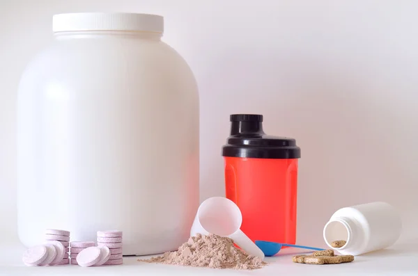 Big jar of protein powder, shaker, pills and tablets