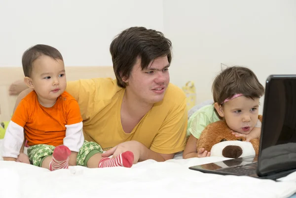 Big brother watching cartoons with his younger sisters