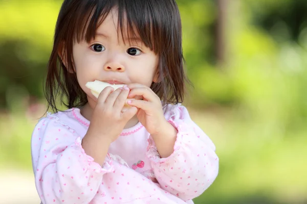 Japanese girl eating rice cracker (1 year old)