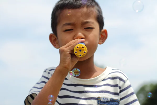 Japanese boy playing with bubble (first grade at elementary school)