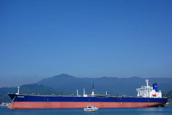Oil tanker and a coast guard vessel in Batumi oil terminal on a sunny summer day.