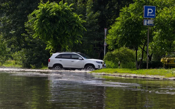 CHERKASSY, UKRAINE- JUNE 5, 2016: cars driving on a flooded road during a flood caused after heavy rain, in Cherkassy.