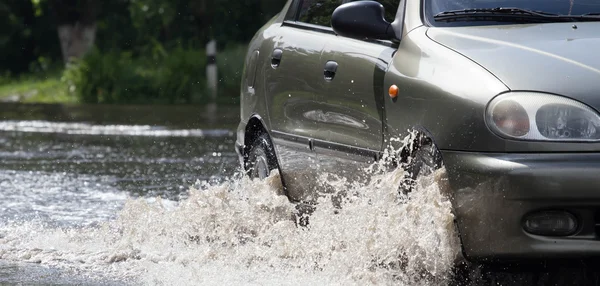 Cars driving on a flooded road during a flood caused after heavy rain