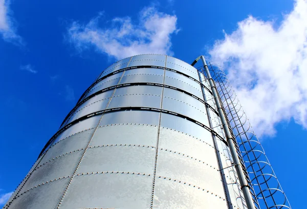 Towering grain silo under blue skies.